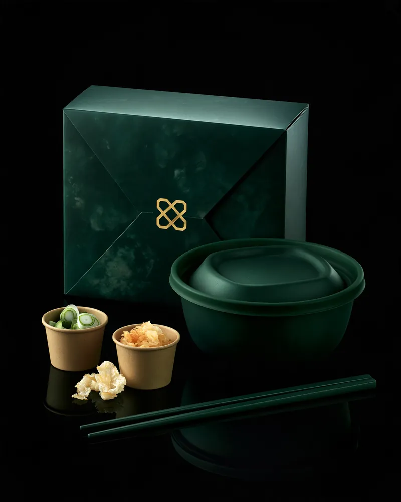 The Jade Noodle jade-textured green box beside its matching molded fiber bowl, topping cups and chopsticks.